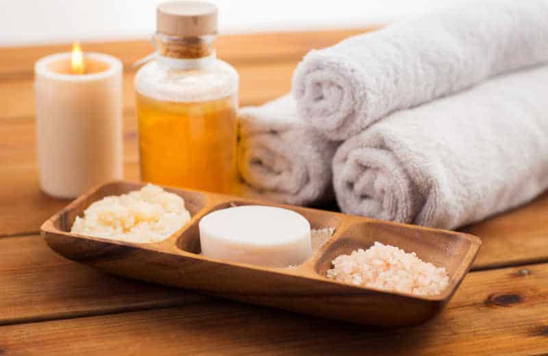 Salt, candles, oil, and towels spa treatment.