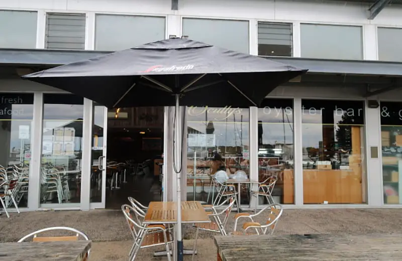 Outdoor dining with a picnic table and umbrella at Scully's Bar and Grill in Queenscliff. 