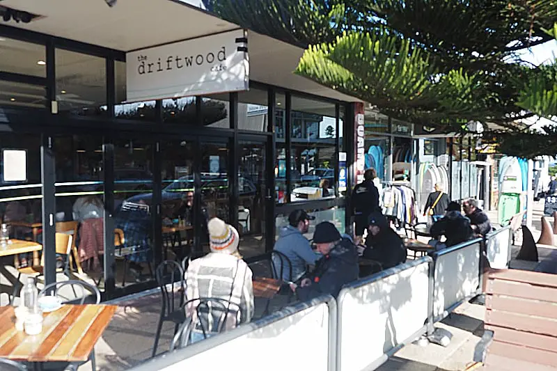People sitting outside in the shade of a tree at Driftwood Cafe Ocean Grove