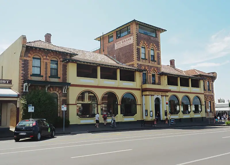 Exterior view of the Vue Grand Hotel restaurant in Queesncliff with arched windows and a tower. 