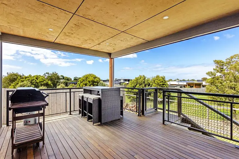 Large wooden deck area with an outdoor setting and barbecue at Aurora accommodation in Apollo Bay. 