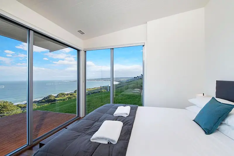 Guest bedroom at Seafarers Getaway accommodation in Apollo Bay with ocean views through its large windows.