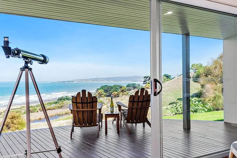 Decked area with outdoor setting, a telescope and panoramic ocean views at Seafarers Getaway one of the best places to stay in Apollo Bay.
