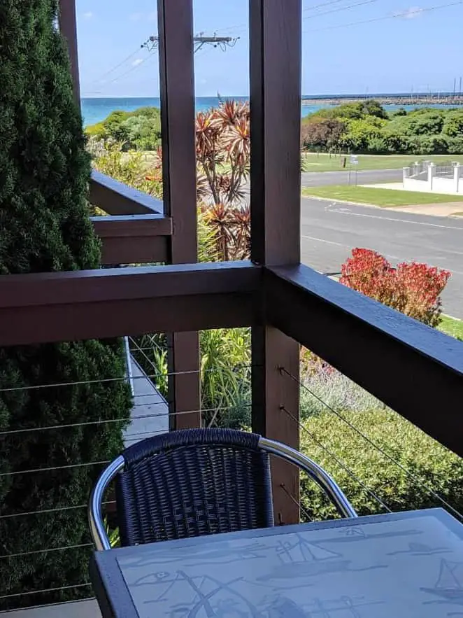 Balcony with outdoor seating and views of the street and ocean in the distance at Seaview Motel & Apartments. A good choice for cheap accommodation in Apollo Bay.