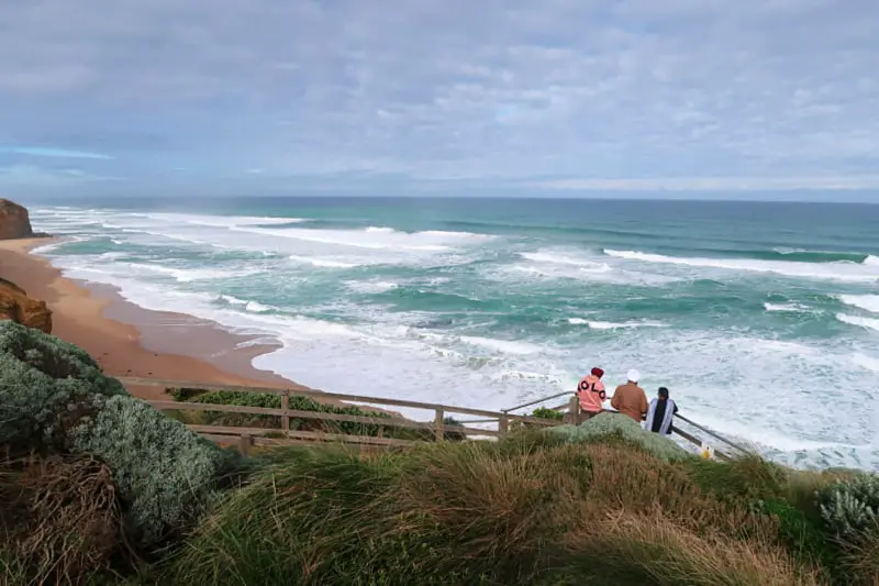 Three people enjoying the view from the top of Gibson Steps on the Great Ocean Road. The best Great Ocean Road tours include a stop here.