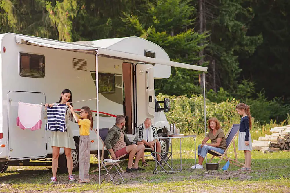 Family relaxing outside their caravan under an awning. There are several family friendly Apollo Bay caravan parks in Victoria.
