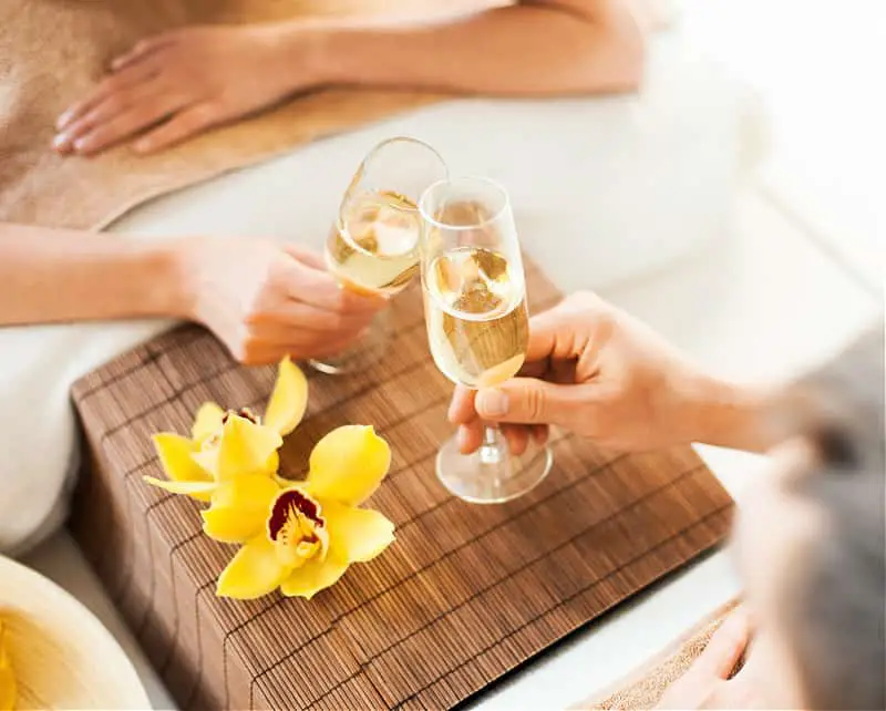 Two people clinking Champaign glasses at a health spa. 