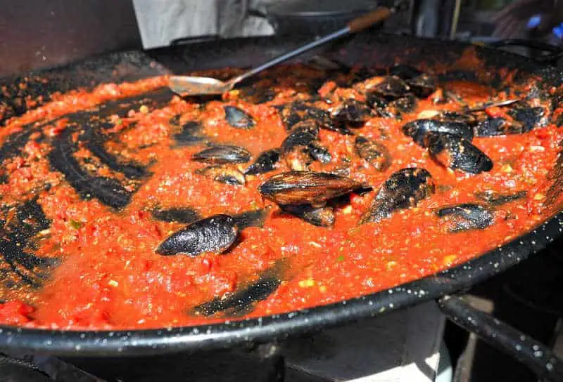 Mussels being stirred in a huge pot of tomato sauce at the Portarlington Mussel Festival on the Bellarine Peninsula in Victoria.