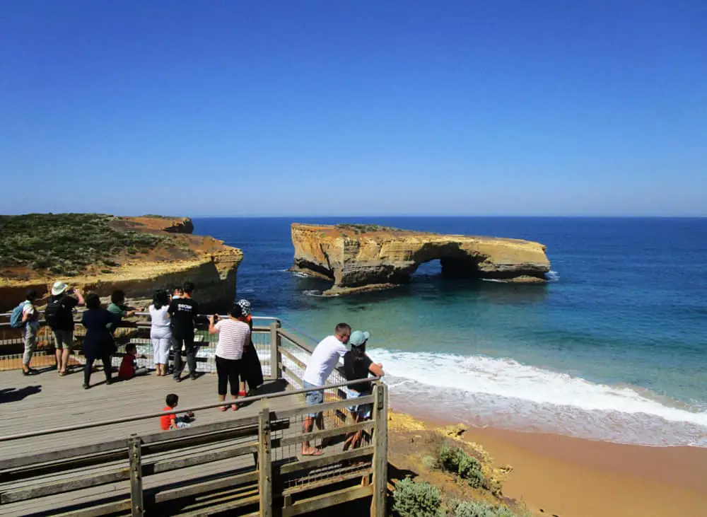 People on a tour viewing the London Arch from a lookout. 2 day Great Ocean Road tours are an excellent way to see all the top attractions along the road.