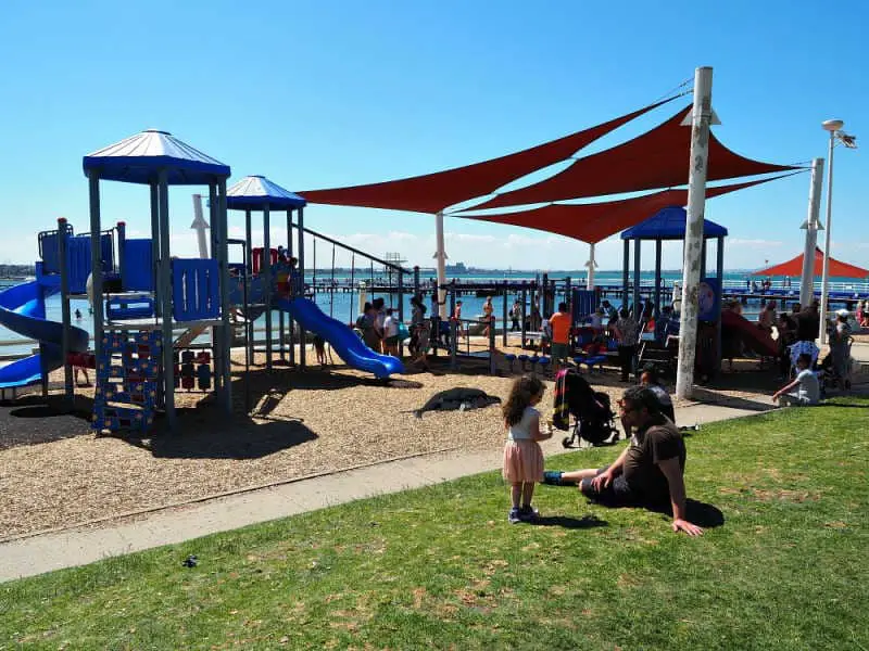 Children's playground at Eastern Beach with sail shades on a clear blue day.