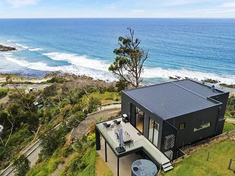 Aerial view of Iluka Blue holiday accommodation sitting on a cliff top above the ocean.