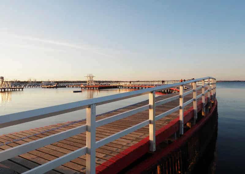 View of the art deco promenade at Eastern Beach with a white railing at sunset.