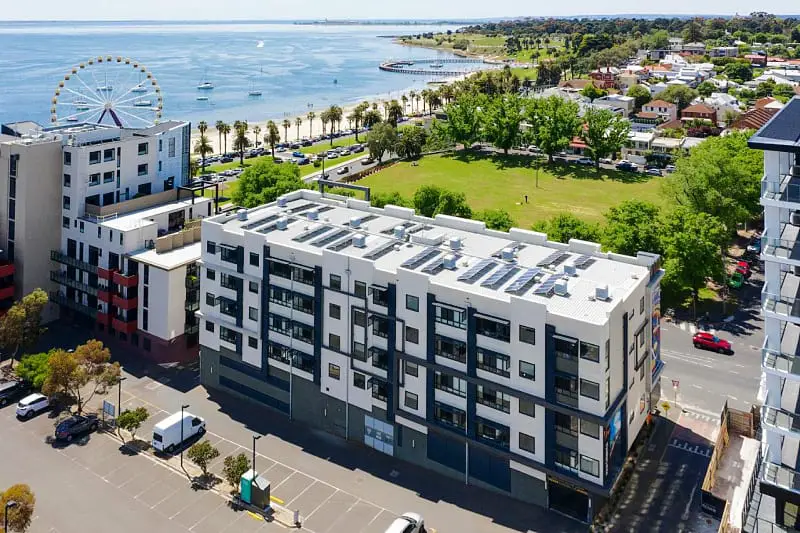 Aerial view of the Vue Apartments Geelong Eastern Beach, Corio Bay, and parklands can be seen.